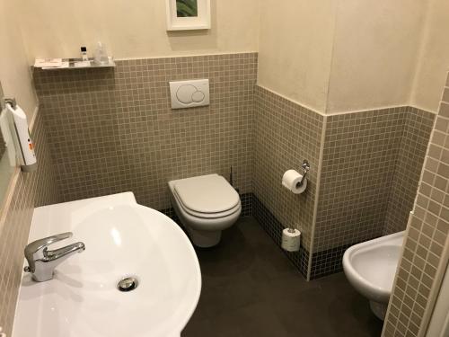 a bathroom with a white sink and a toilet at Bis Hotel Varese in Varese