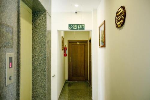 a hallway with a door and a sign on a wall at Manasarovar Homes - Rajalakshmi Serviced Apartments in Tiruvannāmalai