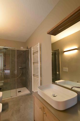 a bathroom with a shower and a sink and a tub at Antico fienile in Belluno