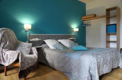 1 dormitorio con 1 cama y 1 silla en Hôtel du Béarn en Bagnères-de-Bigorre