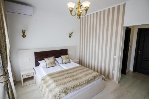 a bedroom with a bed and a chandelier at Hotel-Restaurant Ayan Piatra Neamt in Piatra Neamţ