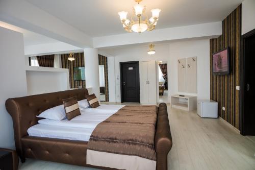 a bedroom with a bed and a couch in it at Hotel-Restaurant Ayan Piatra Neamt in Piatra Neamţ