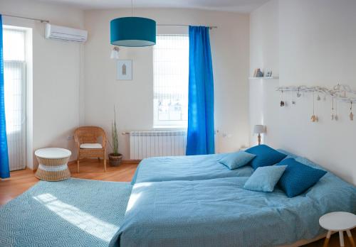 una camera da letto con un letto blu e tende blu di Guest house Maison 21 a Plovdiv