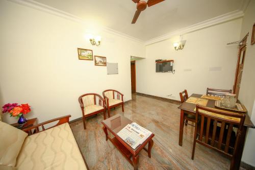 a living room with a couch and a table at Manasarovar Homes - Rajalakshmi Serviced Apartments in Tiruvannāmalai