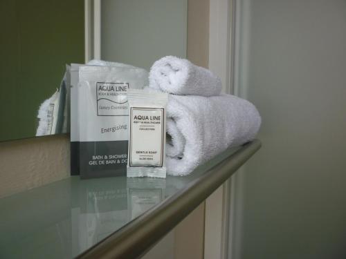 a bathroom counter with towels and other products on it at Hotel Ambrosia in Ypres
