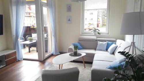 a living room with a couch and a table at Apartament Papaj in Giżycko