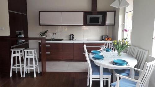 een keuken met een witte tafel met blauwe gerechten erop bij Apartament Papaj in Giżycko