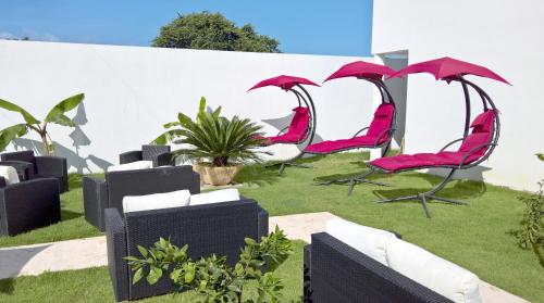 a group of pink chairs sitting on the grass at El Cabarete Spa Resort all-Inclusive in Cabarete