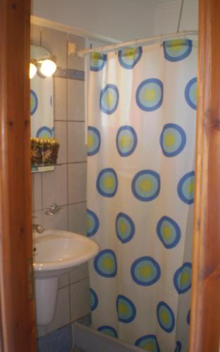 a bathroom with a sink and a shower curtain at DAMIA HOTEL Apts in Sidari