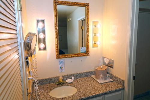 a bathroom with a sink and a mirror at Masterpiece Hotel in Morro Bay