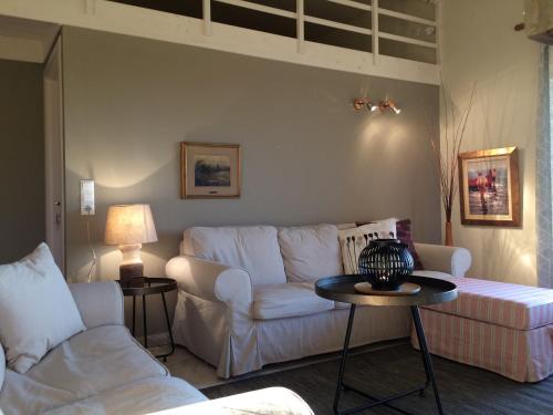 a living room with a white couch and a table at Armonia Villas in Skala Rachoniou