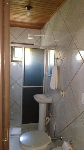 a bathroom with a toilet and a sink at Hospedaria Ondas do Rosa in Praia do Rosa
