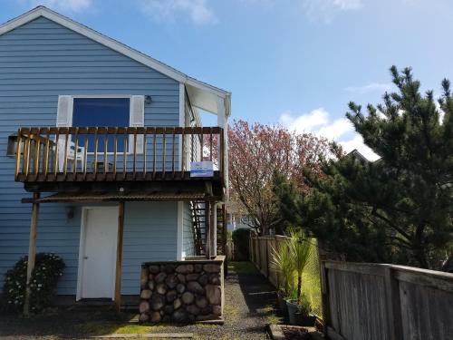 a house with a deck and a fence at The Guesthouse Ocean View Cottages in Cannon Beach