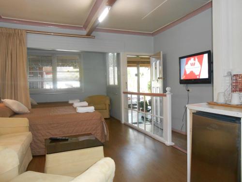 a living room with a bed and a tv at Mount View Motel in Bulahdelah