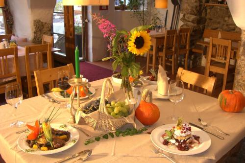 a table with plates of food and a vase with a sunflower at Ropferhof in Telfs-Buchen