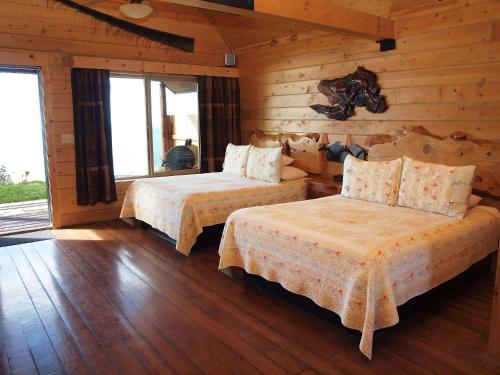 a bedroom with two beds in a log cabin at Alaskan Suites in Homer