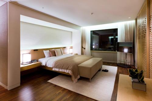 a bedroom with a large bed and a large window at Hotel Hyundai by Lahan Ulsan in Ulsan