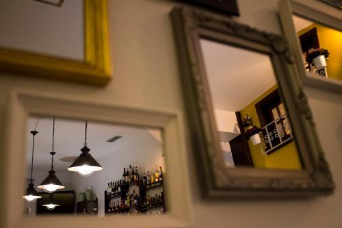 a mirror on a wall with a reflection of a room at Charme e Alegria in Viseu