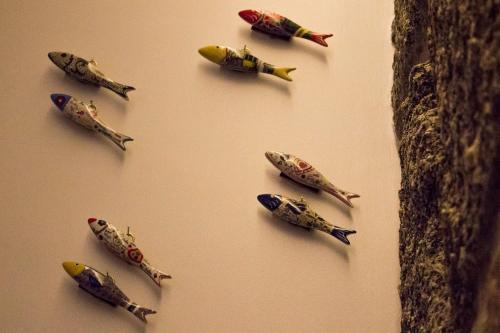 a group of toy fish on a wall at Charme e Alegria in Viseu