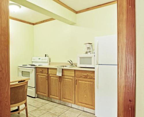 a kitchen with a white refrigerator and a microwave at Travelodge by Wyndham Golden Sportsman Lodge in Golden