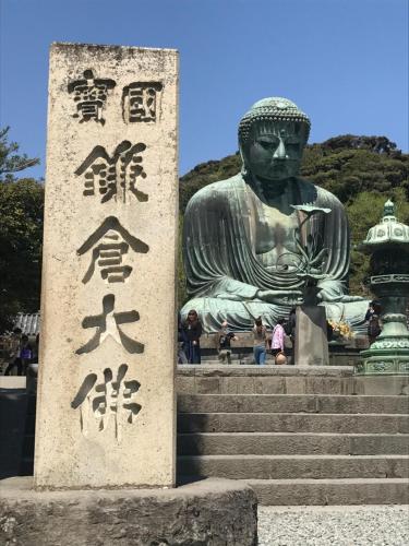 a statue of a woman sitting on some steps at guesthouse SHIBAFU in Kamakura