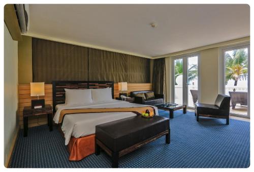ボラカイにあるボラカイ サンズ ホテルの大きなベッドと椅子が備わるホテルルームです。