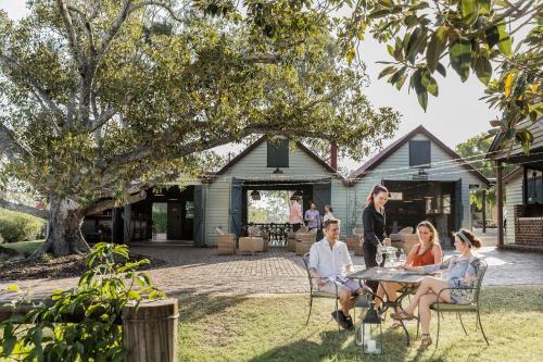 a group of people sitting around a table in a yard at Spicers Hidden Vale in Grandchester