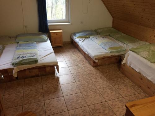 Zimmer mit 3 Betten und einem Fenster in der Unterkunft Chata Oravská Priehrada in Námestovo