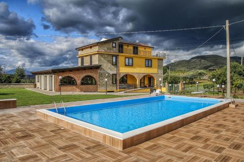 a villa with a swimming pool in front of a house at Tenuta Cerreto in Calvi Vecchia