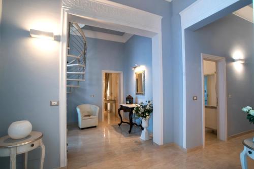 a hallway with blue walls and a table and chairs at Palazzo Bove in Galatone