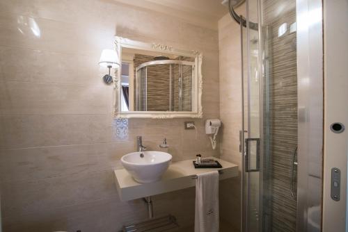 a bathroom with a sink and a mirror and a shower at Palazzo Bove in Galatone