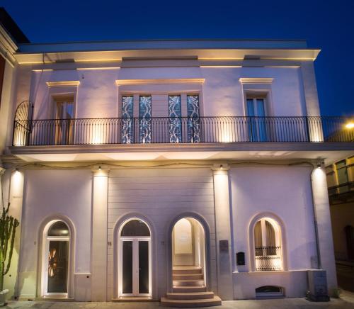 a white house with a balcony at night at Palazzo Bove in Galatone