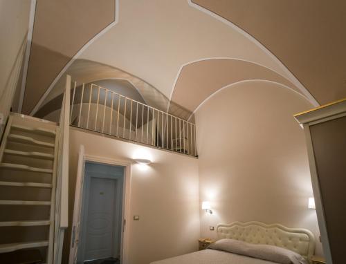 a bedroom with a spiral staircase and a bed at Palazzo Bove in Galatone