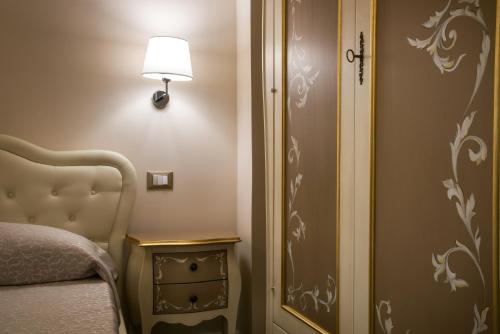 a bedroom with a bed and a lamp next to a door at Palazzo Bove in Galatone