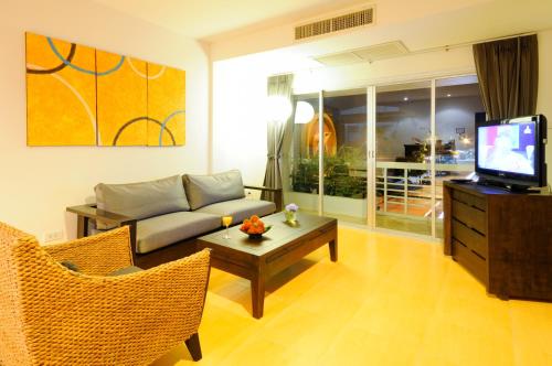 a living room with a couch and a tv at Kasemsarn Hotel Chanthaburi in Chanthaburi