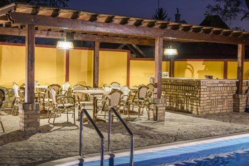 a patio with a table and chairs next to a pool at Amfora in Palić