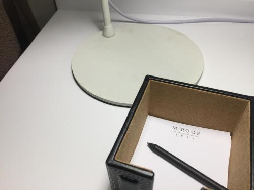 a cell phone sitting on a desk with a pen at M Roof Hotel & Residences in Ipoh