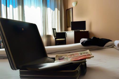 a laptop computer sitting on a bed in a hotel room at Hotel Alexander in Sofia