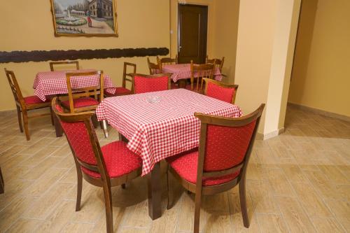 a dining room with red and white table and chairs at Amfora in Palić