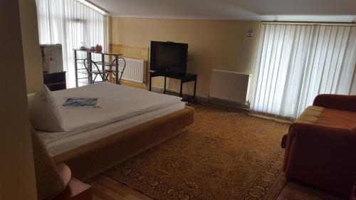 a bedroom with a bed and a flat screen tv at Hotel Confort Drochia in Drochia