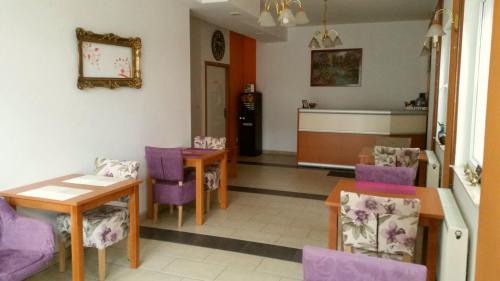 a dining room with purple chairs and a table at Pansion Centar in Tuzla