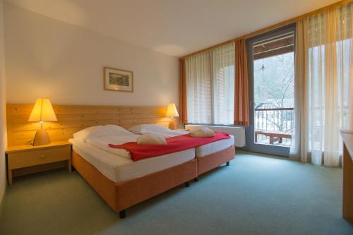 a bedroom with a bed and a large window at Hotel Bergkristall in Wildalpen