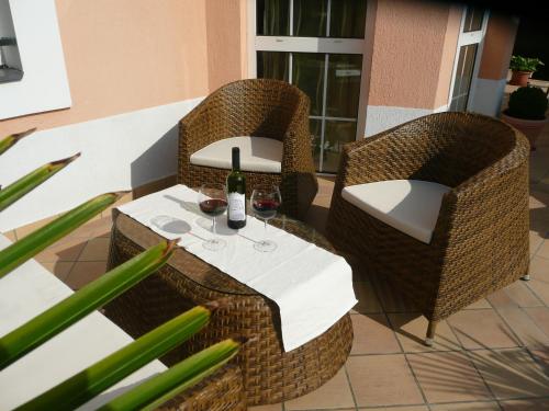 a table and chairs with a bottle of wine on it at Barackvirág Vendégház in Tihany