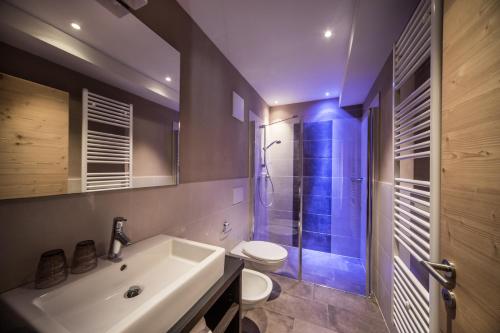 a bathroom with a white sink and a toilet at Monti Pallidi B&B Apartments in Corvara in Badia