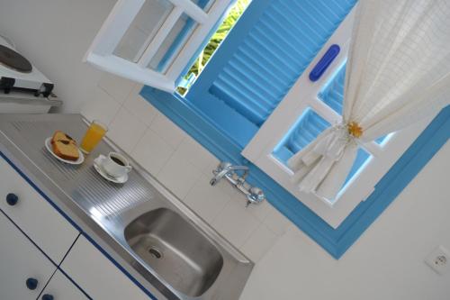 a small kitchen with a sink and a window at Ostria Hotel & Apartments in Gavrio