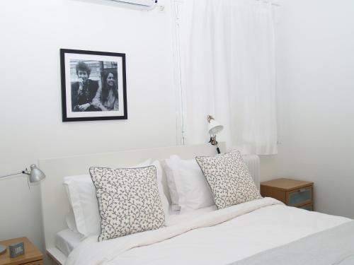 a white bedroom with a white bed with pillows at Artistic Deco Apartment in Athens