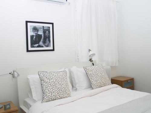 Dormitorio blanco con cama blanca y almohadas en Artistic Deco Apartment, en Atenas