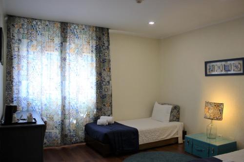 a small bedroom with a bed and a window at Hotel A.S. Lisboa in Lisbon