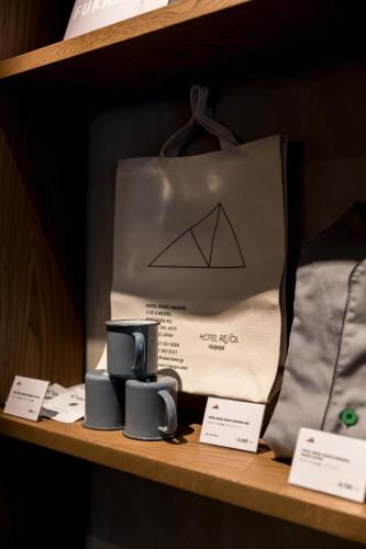 a paper bag and two mugs on a shelf at Hotel Resol Nagoya in Nagoya