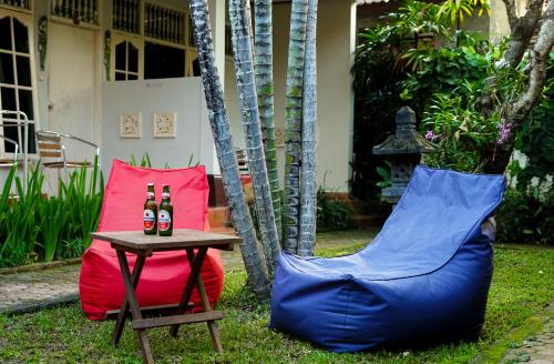 two bottles of beer on a table and two chairs at Little Pond Homestay in Sanur